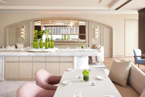 a restaurant with pink chairs and tables and a counter at Four Seasons Hotel Tokyo at Marunouchi in Tokyo