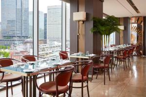 a restaurant with tables and chairs and a view of the city at Four Seasons Hotel Tokyo at Marunouchi in Tokyo