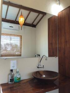 a bathroom with a wooden sink on a counter at Pousada Porto Taipus in Marau