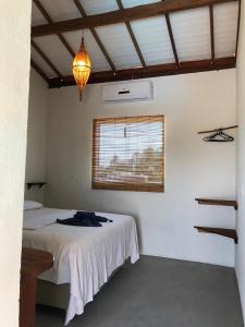 um quarto com uma cama num quarto com uma janela em Pousada Porto Taipus em Marau