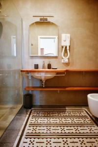 y baño con lavabo y espejo. en Villa le Pigne, en Malfa