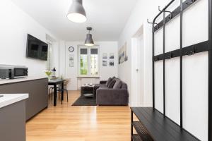 a kitchen and a living room with a couch at Chlebnicka Apartments in Gdańsk Old Town by Renters in Gdańsk