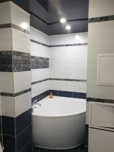 ein Badezimmer mit einer weißen Badewanne und einem Waschbecken in der Unterkunft Симбирские апартаменты на Варейкиса 42 in Uljanowsk