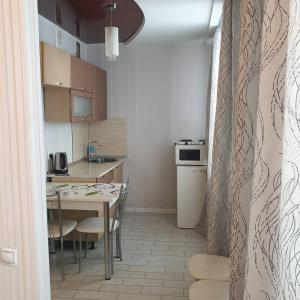 a small kitchen with a table and a dining room at Симбирские апартаменты на Варейкиса 42 in Ulyanovsk