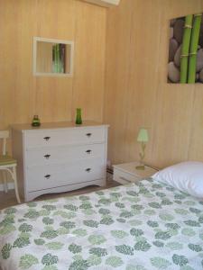 ein Schlafzimmer mit einem weißen Bett und einer Kommode in der Unterkunft Gîte de La Garenne in Cozes