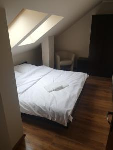 1 dormitorio con 1 cama blanca y tragaluz en Adlerek Krynica, en Krynica Morska