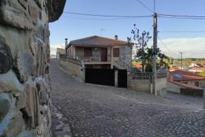 une maison sur un mur en pierre à côté d'une rue dans l'établissement Casa Rural La Vizana, à Alija de los Melones