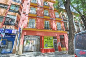 塞維利亞的住宿－Piso Triana, Sevilla，街道边的红色建筑