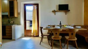 comedor con mesa y sillas y cocina en Casa Malpaga Tenna Ospitar en Tenna 