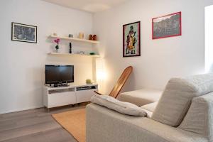 ein Wohnzimmer mit einem Sofa und einem TV in der Unterkunft Casa Mincoti Piazza Terragnolo OSPITAR in Piazza