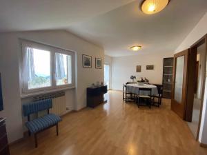 a living room with a table and chairs and a window at Casa da Nonno Clode Belvedere Tressilla Ospitar in Baselga di Pinè