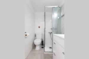 a bathroom with a toilet and a glass shower at Horizonte Atlántico: Un Rincón en el Paraíso in Azano