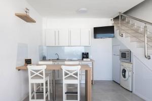a kitchen with a table and some white cabinets at Horizonte Atlántico: Un Rincón en el Paraíso in Azano