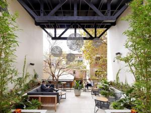 a courtyard with people sitting on couches in a building at Harbour Rocks Hotel Sydney in Sydney