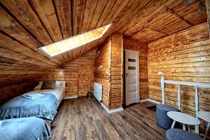 ナウェンチュフにあるBelwederの木造キャビン内のベッド2台が備わる部屋