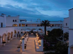 - une vue sur un bâtiment la nuit avec des lumières dans l'établissement Borgobianco Resort & Spa Polignano - MGallery Collection, à Polignano a Mare