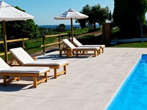 a row of chairs and umbrellas next to a pool at Monte de Portugal in Montargil