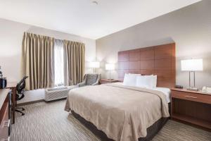 um quarto de hotel com uma cama grande e uma cadeira em Quality Inn & Suites em Lodi