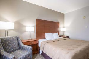 a hotel room with a bed and a chair at Quality Inn & Suites Lodi I-90 in Lodi +34 photos