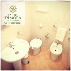 Un baño con un inodoro blanco y un lavabo. en B&B La Tua Dimora, en Palermo