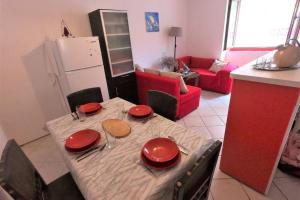 una cocina con una mesa con placas rojas. en Una's House of Joy, en Isla Krapanj