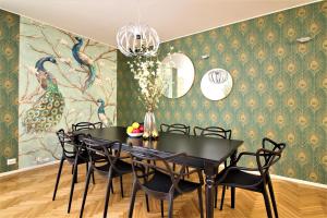 une salle à manger avec une table et des chaises noires dans l'établissement Tallinn City Apartments 4 bedroom with sauna and 2 bathroom, à Tallinn