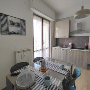 cocina con mesa y sillas en Nonna Pella Casa Vacanze appartamento Ginestra, en Pietra Ligure