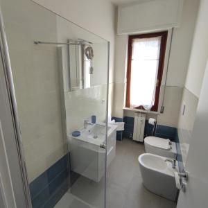 Baño blanco con lavabo y aseo en Nonna Pella Casa Vacanze appartamento Ginestra, en Pietra Ligure