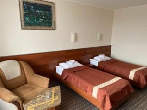 烏日霍羅德的住宿－Intourist-Zakarpattia Hotel，酒店客房,配有两张床和椅子