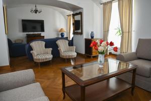 uma sala de estar com um vaso de flores numa mesa de centro em Rákóczi-Dessewffy Kastély Vendégház em Tokaj