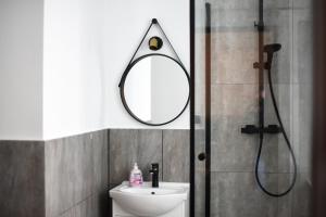 een badkamer met een wastafel en een spiegel bij Perfect Stay - "Apartamenty Horzyca" in Toruń