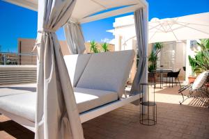 a bed on a balcony with an umbrella at Leopoldo Rooms in Cagliari