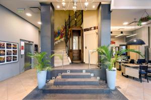 un vestíbulo con escaleras y plantas en una tienda en Milhouse Avenue, en Buenos Aires