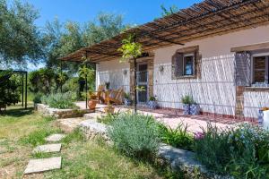 un patio trasero con una casa con pérgola en The Storage House en Danilia