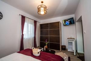a bedroom with a bed and a tv on the wall at Eden House in Costinesti