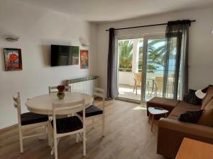 a living room with a table and a couch at Apartments Ajka in Rab