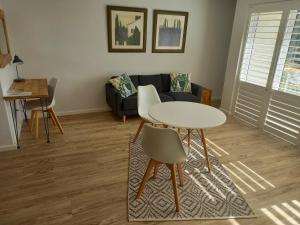 a living room with a table and a couch at Stonebrook Apartments in Simonʼs Town