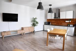a kitchen and dining room with a table and a tv at Perfect Stay - "Apartamenty Horzyca" in Toruń