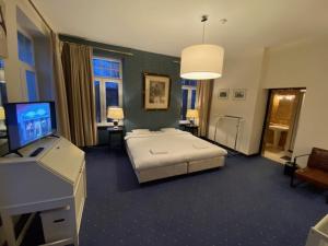 Dormitorio con cama, escritorio y TV en Le Tri Renard Spa en Spa