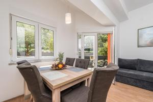 a dining room with a table and chairs and a couch at Villa Mihaela in Trogir