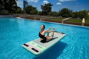 a woman on a paddle board in a swimming pool at Capella Bangkok in Bangkok