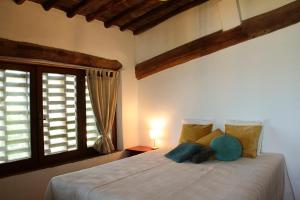 カステッリーナ・イン・キアンティにあるCasina Di Corniaのベッドルーム1室(大型ベッド1台、窓2つ付)