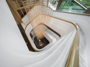 a spiral staircase in a room with a window at Capella Bangkok in Bangkok