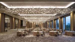 a banquet hall with tables and chairs and a chandelier at Capella Bangkok in Bangkok