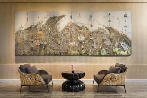 a large map hanging on a wall with chairs and a table at Capella Bangkok in Bangkok