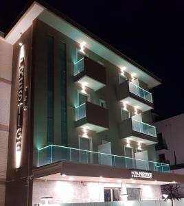 a building with green lights on the side of it at Hotel Prestige in Rimini