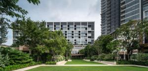 a large building with a park in front of it at Capella Bangkok in Bangkok