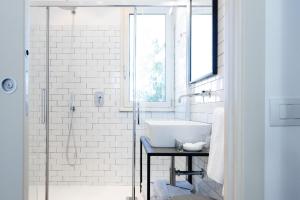 a white bathroom with a sink and a shower at Leopoldo Rooms in Cagliari +22 photos