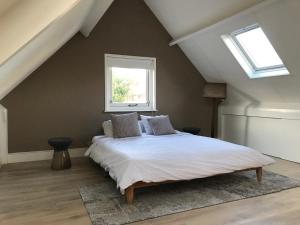 a bedroom with a large white bed with a window at Guest House Amersfoort Center in Amersfoort
