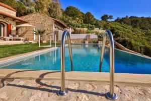 a swimming pool with metal hand rails next to a house at Hotel and Villa Kale Suites, heated pool in winter, adults only in Kas